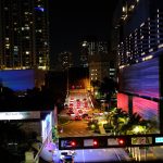 Vista noturna de Brickell, em Miami, com arranha-céus iluminados, trânsito e luzes da cidade.