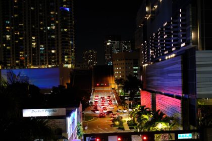 Vista noturna de Brickell, em Miami, com arranha-céus iluminados, trânsito e luzes da cidade.