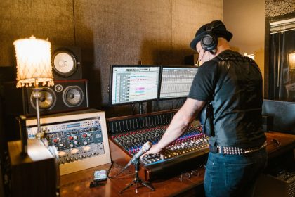 Produtor musical trabalha em uma mesa de mixagem em um estúdio profissional de gravação.