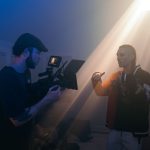 Videógrafo registra uma cena com iluminação cinematográfica em um set de filmagem