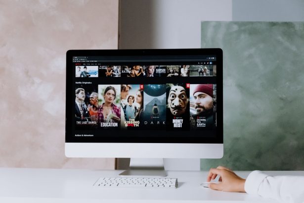 Tela de computador exibindo séries da Netflix em um espaço de trabalho moderno