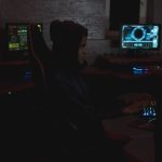 Profissional analisa dados em múltiplos monitores em um centro de operações de cibersegurança.